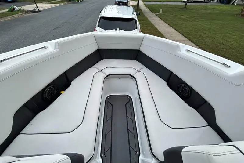 Slide: The Image of 2019 Rinker Q3 OB boat interior with white cushioned seating and black accents. - 4