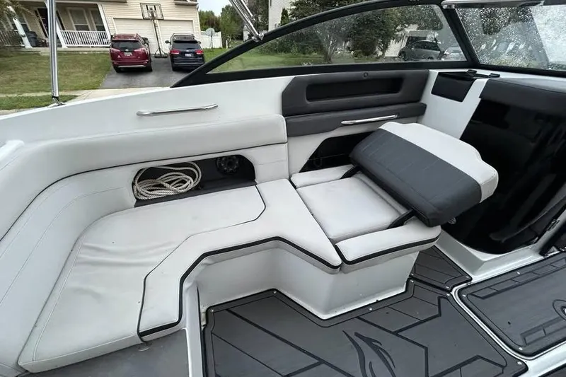 Slide: The Image of Interior of a 2019 Rinker Q3 OB boat with white seating and storage compartment. - 5