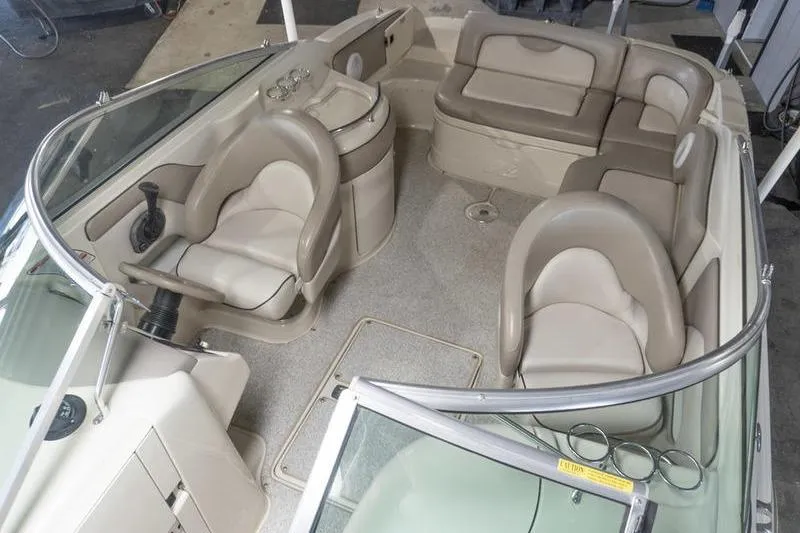 Slide: The Image of Interior of a 2002 Sea Ray 270 Sundeck boat with beige seating and helm. - 11