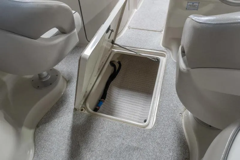 Slide: The Image of 2002 Sea Ray 270 Sundeck interior with open storage compartment and seating. - 12