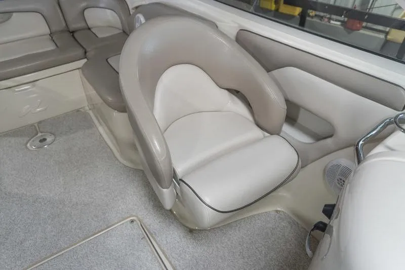 Slide: The Image of Interior seating of a 2002 Sea Ray 270 Sundeck boat, featuring beige upholstery. - 21