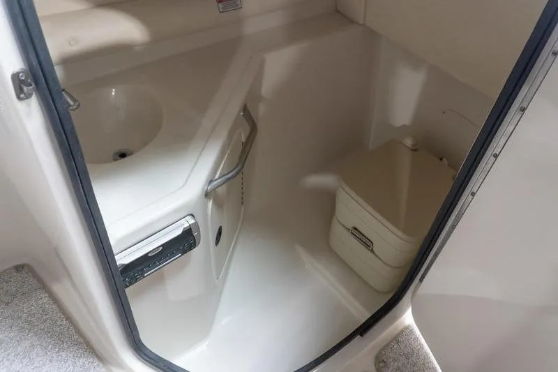Slide: The Image of Interior of 2002 Sea Ray 270 Sundeck boat showing compact bathroom area. - 23