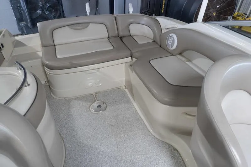 Slide: The Image of Interior seating of a 2002 Sea Ray 270 Sundeck boat, featuring beige and gray upholstery. - 25