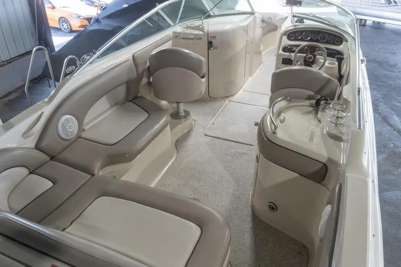 Slide: The Image of Interior view of a 2002 Sea Ray 270 Sundeck boat with beige seating and dashboard. - 3