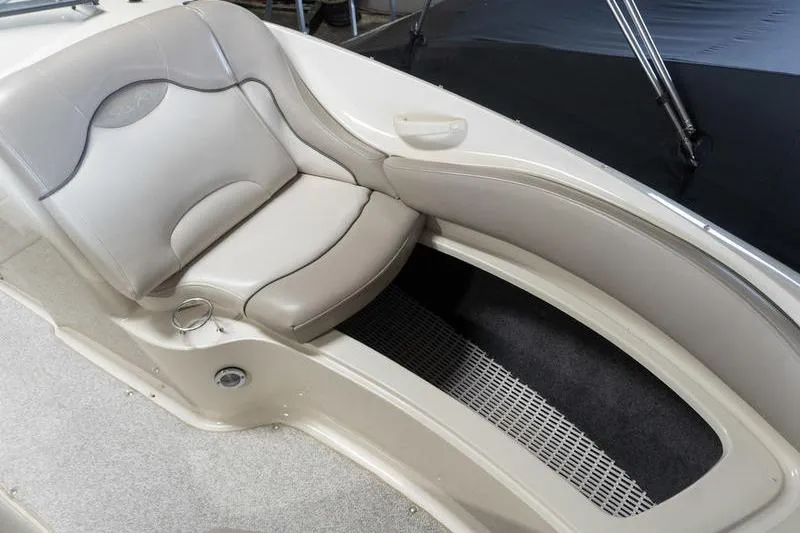 Slide: The Image of Interior seating of a 2002 Sea Ray 270 Sundeck boat, featuring beige upholstery. - 8