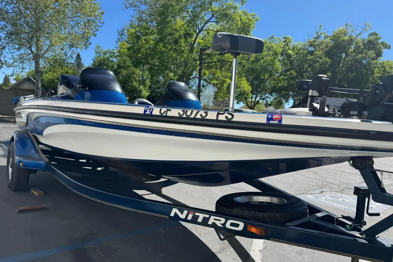 Slide: The Image of 2000 Nitro 901 CDX DC boat on trailer, parked outdoors under clear blue sky. - 5
