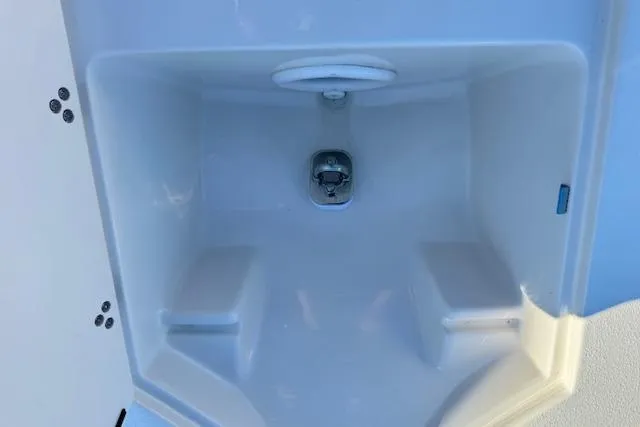 Slide: The Image of 2026 Carolina Skiff 21 LS boat storage compartment, white interior, open hatch. - 15