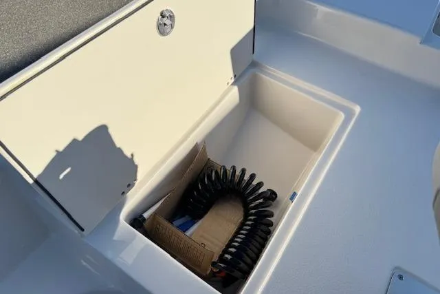Slide: The Image of Storage compartment in 2026 Carolina Skiff 21 LS boat with coiled hose. - 17
