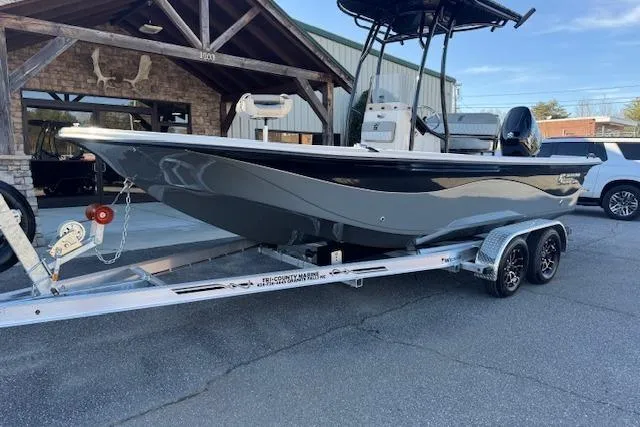 Slide: The Image of 2026 Carolina Skiff 21 LS boat on trailer, parked outside a building. - 2