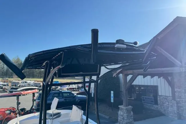 Slide: The Image of 2026 Carolina Skiff 21 LS boat with T-top and rod holders in a marina setting. - 24