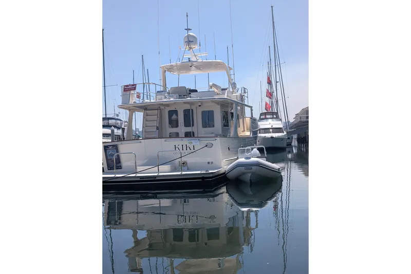 Slide: The Image of Tide Craft Catalina 13 boat docked in marina, 2026 model, calm water reflection. - 14