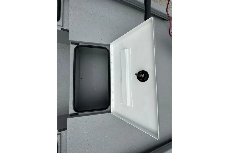 Slide: The Image of Open storage compartment in 2026 Vexus Defender 201 boat, featuring a secure latch. - 12