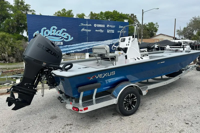 Slide: The Image of 2026 Vexus Defender 201 boat with Suzuki engine on trailer, parked outdoors. - 2