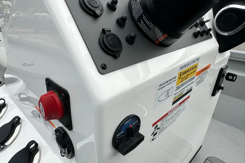 Slide: The Image of Control panel of 2026 Vexus Defender 201 boat with safety labels and switches. - 27