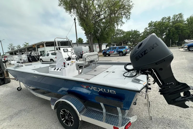 Slide: The Image of 2026 Vexus Defender 201 boat with Suzuki outboard motor in a parking area. - 3