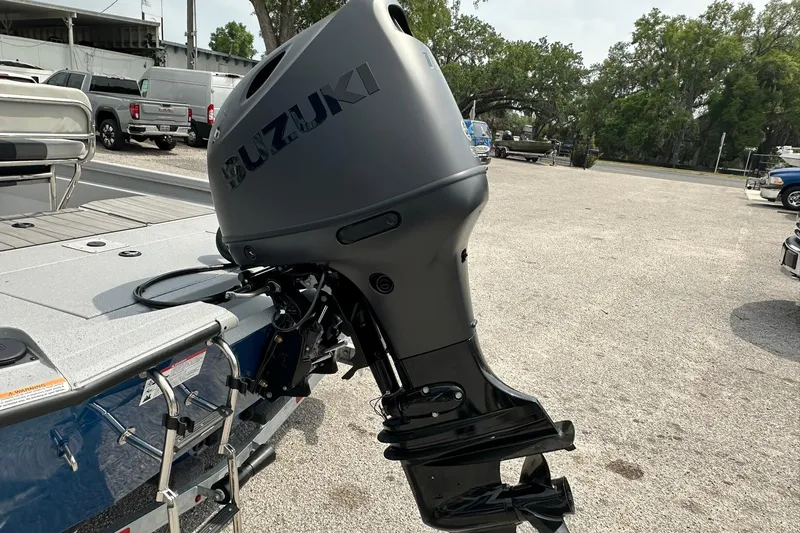 Slide: The Image of 2026 Vexus Defender 201 boat with Suzuki outboard motor in a parking area. - 39