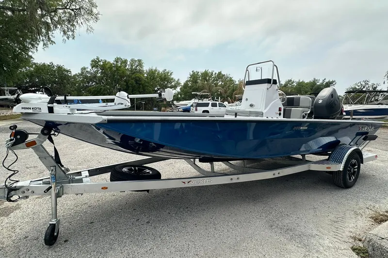 Slide: The Image of 2026 Vexus Defender 201 boat on trailer, featuring blue hull and Minn Kota trolling motor. - 4