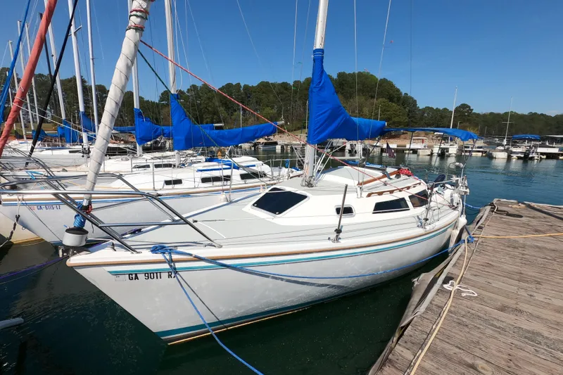 The Image of 1990 Catalina Capri 26 sailboat docked at a marina with blue covers. - 0