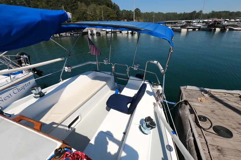 Slide: The Image of Catalina Capri 26 sailboat docked, featuring blue canopy and American flag, 1990 model. - 10