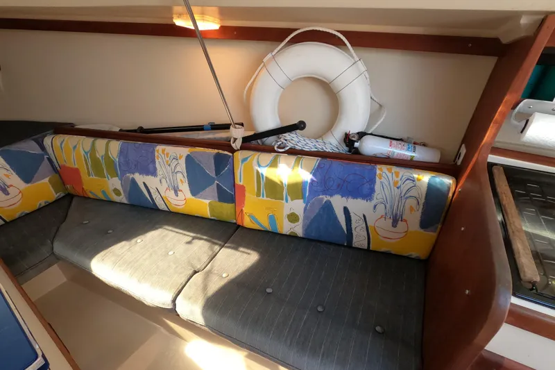 Slide: The Image of Interior of 1990 Catalina Capri 26 sailboat with colorful cushions and safety equipment. - 17