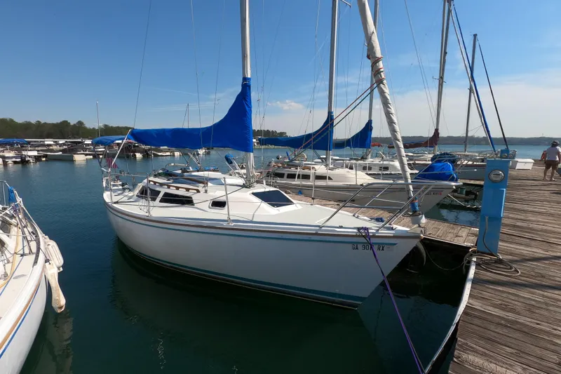 Slide: The Image of 1990 Catalina Capri 26 sailboat docked at marina with blue sail covers. - 2