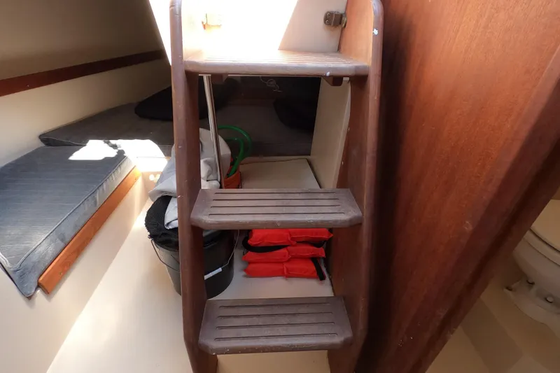Slide: The Image of Interior of 1990 Catalina Capri 26 sailboat with wooden steps and cabin storage. - 23