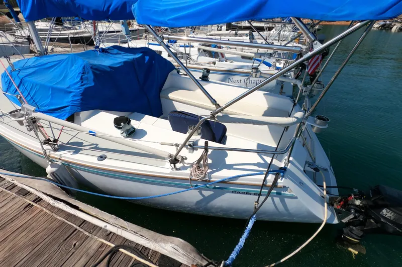 Slide: The Image of 1990 Catalina Capri 26 sailboat docked with blue covers and visible outboard motor. - 5