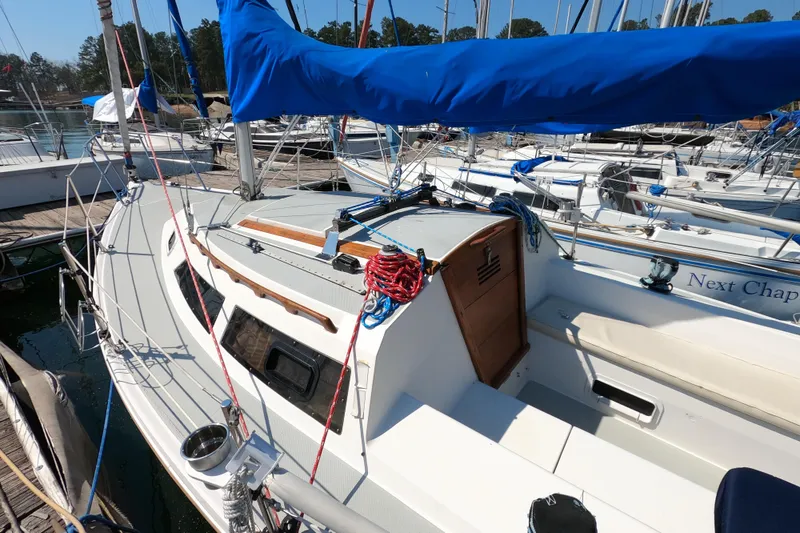 Slide: The Image of 1990 Catalina Capri 26 sailboat docked, featuring blue sail cover and tidy deck. - 8