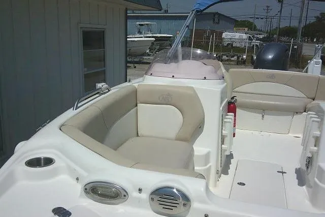 Slide: The Image of 2018 NauticStar 193 SC Deck boat interior with beige seating and white deck. - 13