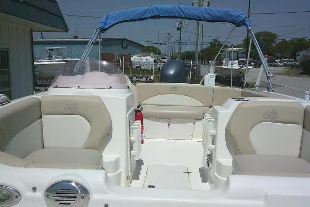 Slide: The Image of 2018 NauticStar 193 SC Deck boat interior with beige seating and blue canopy. - 15