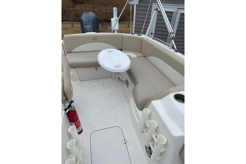 Slide: The Image of 2018 NauticStar 193 SC Deck boat interior with seating, table, and fire extinguisher. - 5