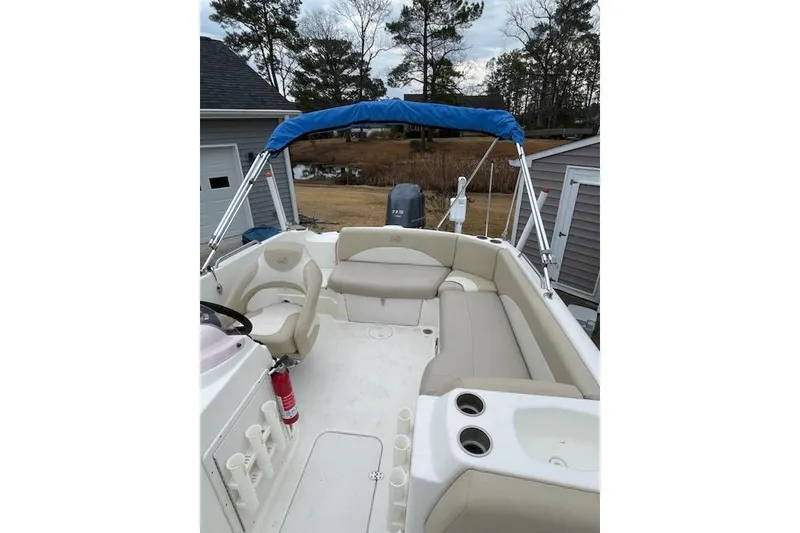 Slide: The Image of 2018 NauticStar 193 SC Deck boat interior with seating and blue canopy. - 6