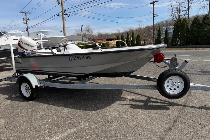 Slide: The Image of 2004 Boston Whaler 150 Sport boat on trailer, parked outdoors. - 2