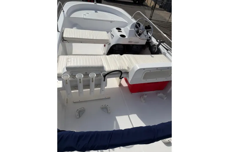 Slide: The Image of 2004 Boston Whaler 150 Sport boat interior with seating and steering wheel. - 6