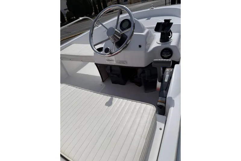 Slide: The Image of 2004 Boston Whaler 150 Sport boat interior with steering wheel and seating. - 7