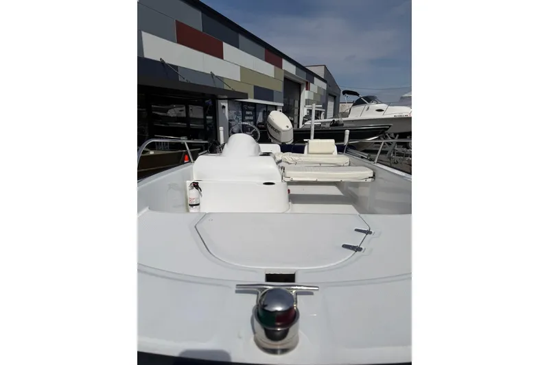 Slide: The Image of 2004 Boston Whaler 150 Sport boat displayed outdoors, showcasing sleek design and seating area. - 9