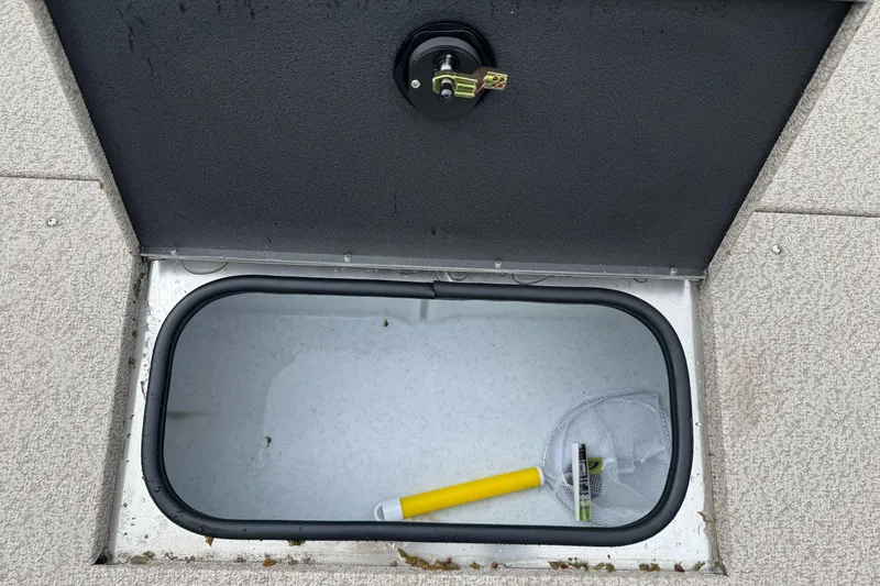 Slide: The Image of Open storage compartment in 2026 Lund 2075 Alaskan SS boat with net and handle inside. - 11