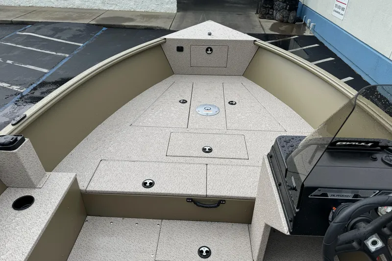 Slide: The Image of 2026 Lund 2075 Alaskan SS boat interior with storage compartments and steering console. - 13