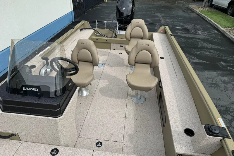 Slide: The Image of 2026 Lund 2075 Alaskan SS boat interior with beige seating and steering console. - 15