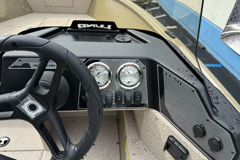 Slide: The Image of 2026 Lund 2075 Alaskan SS boat dashboard with steering wheel and gauges. - 17