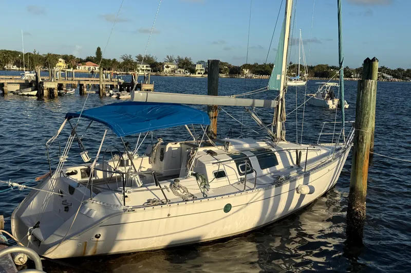 The Image of 1990 Beneteau First 32s5 sailboat docked in a sunny marina setting. - 0