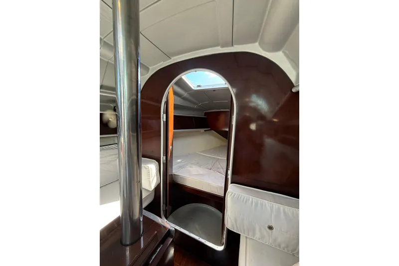 Slide: The Image of Interior cabin of 1990 Beneteau First 32s5 sailboat, featuring cozy sleeping quarters. - 11