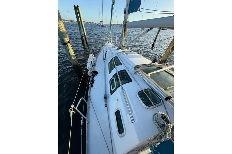 Slide: The Image of 1990 Beneteau First 32s5 sailboat docked, showcasing deck and rigging details. - 18