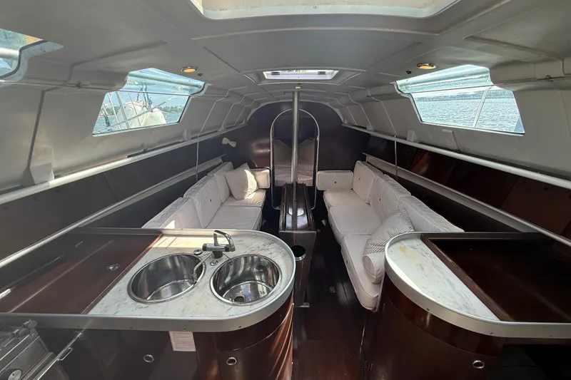 Slide: The Image of Interior of 1990 Beneteau First 32s5 sailboat with white seating and dual sinks. - 25