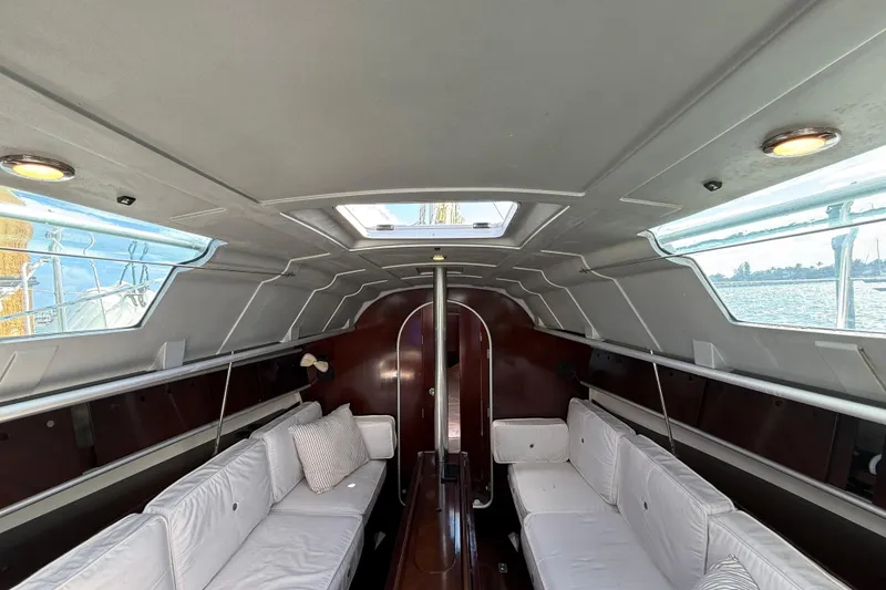 Slide: The Image of Interior of 1990 Beneteau First 32s5 sailboat with white seating and wood accents. - 27