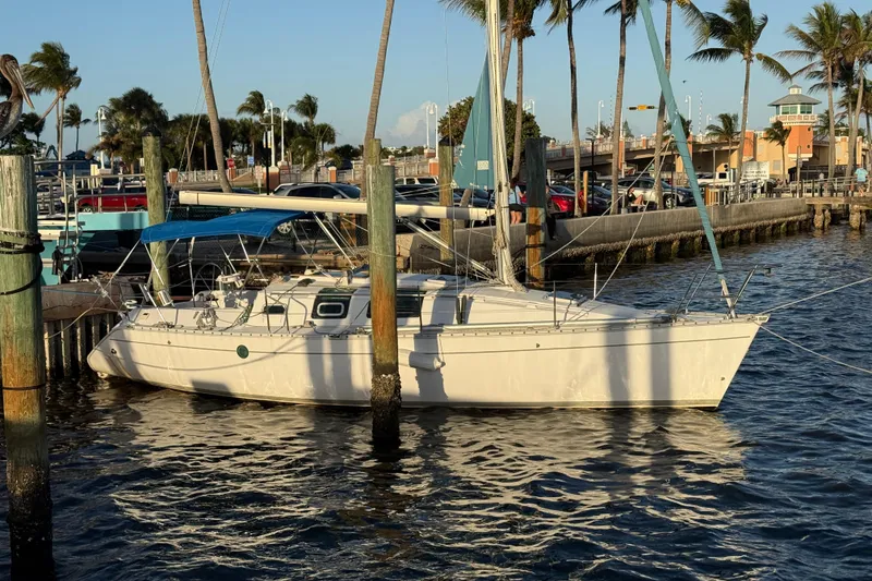 Slide: The Image of Sailboat Beneteau First 32s5, 1990 model, docked at marina with palm trees. - 3