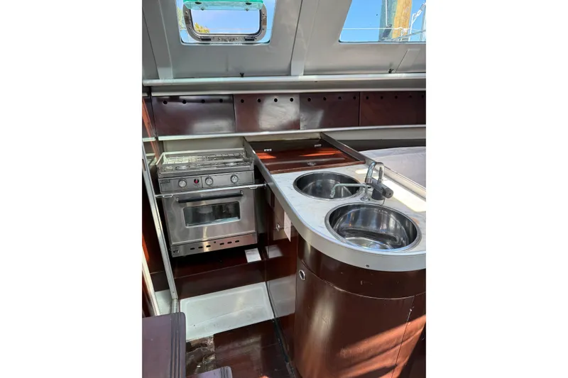 Slide: The Image of Interior of 1990 Beneteau First 32s5 yacht kitchen with stove and dual sinks. - 34
