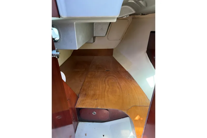 Slide: The Image of Interior cabin of 1990 Beneteau First 32s5 sailboat, featuring wooden flooring and compact design. - 36