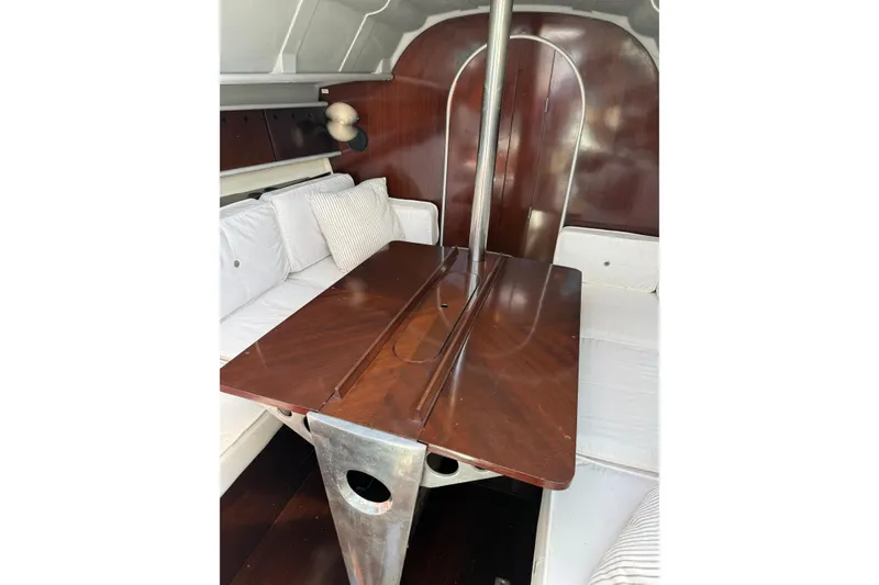 Slide: The Image of Interior of 1990 Beneteau First 32s5 sailboat with wooden table and white seating. - 40