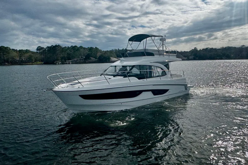 The Image of 2026 Beneteau Antares 11 Fly cruising on a serene lake under cloudy skies. - 1